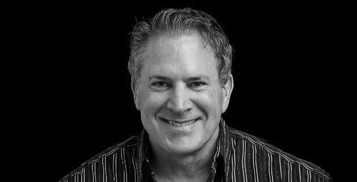 Black and white portrait of Brittain Ladd, smiling at the camera.