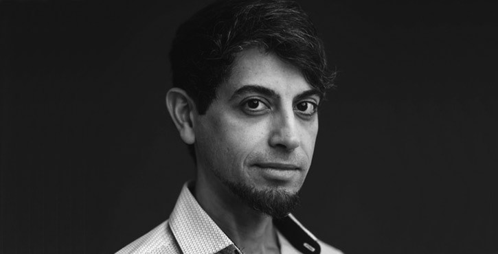 Portrait of Haitham Al-Beik, looking serious with a black background.