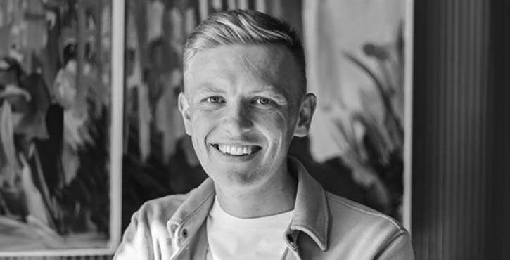Black and white portrait of Ian Keating smiling cheerfully.