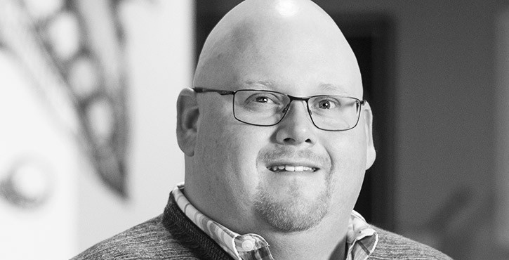Portrait photo of a bald man wearing glasses and a slight smile.