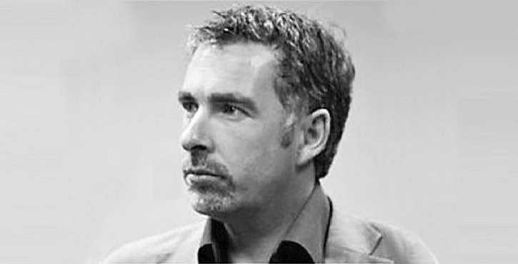 Portrait of Mark Dempsey, looking thoughtful with grey hair and an open-necked shirt.