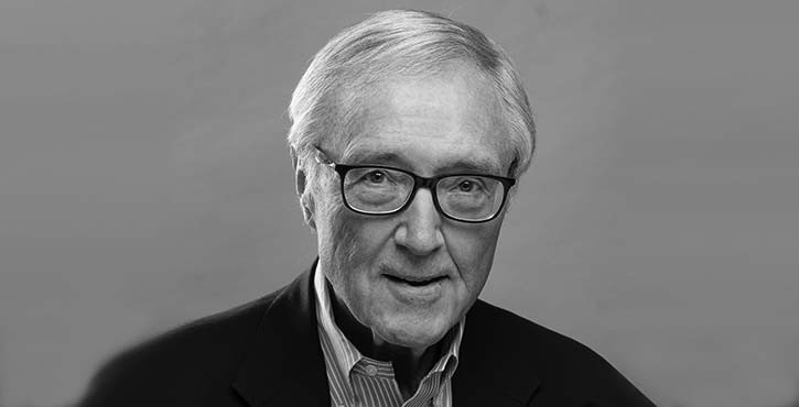 Portrait of an elderly man wearing glasses, looking into the camera.