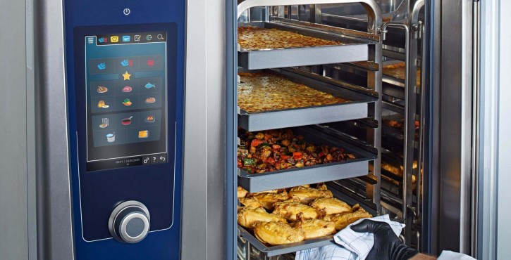  iCombi Pro de Rational ouvert avec des plateaux remplis de plats cuits au four.