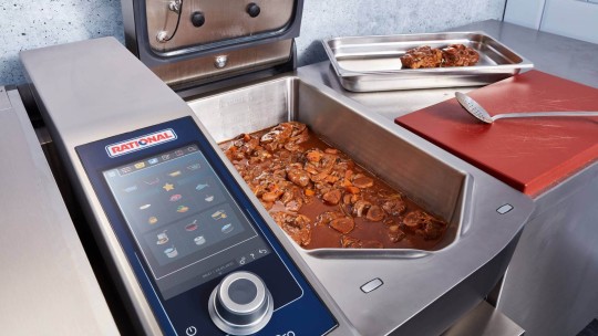 Rational iVario Pro with ragout in the cooking pan and a ladle beside it.