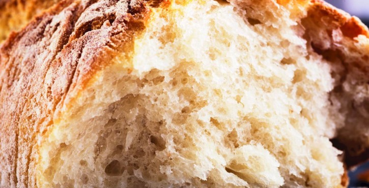 Gros plan sur un pain croustillant dont l'intérieur est moelleux et aéré.