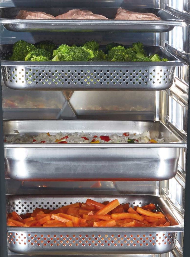 Brocoli, poulet, riz avec poivrons et bâtonnets de carotte dans des récipients en acier inoxydable.