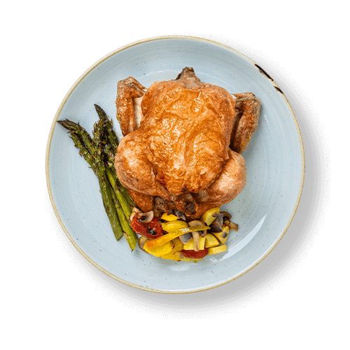 Plate of roasted whole chicken served with grilled asparagus and mixed vegetables.