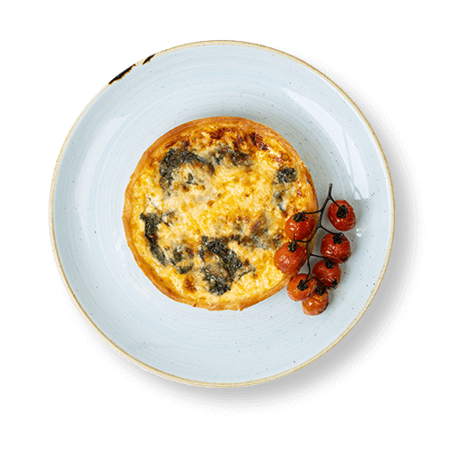 Plate of baked quiche served with roasted cherry tomatoes.
