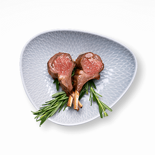 A plate featuring two perfectly cooked lamb chops garnished with fresh rosemary, served on a decorative dish.