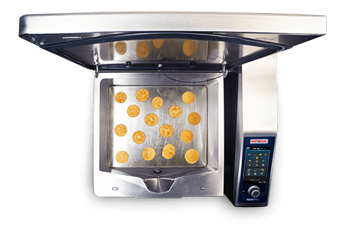 The Rational iVario Pro L  cooking appliance with an open lid, featuring pancakes evenly placed on the cooking surface.
