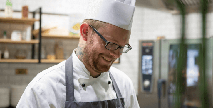 Un chef heureux travaillant avec un appareil RATIONAL.
