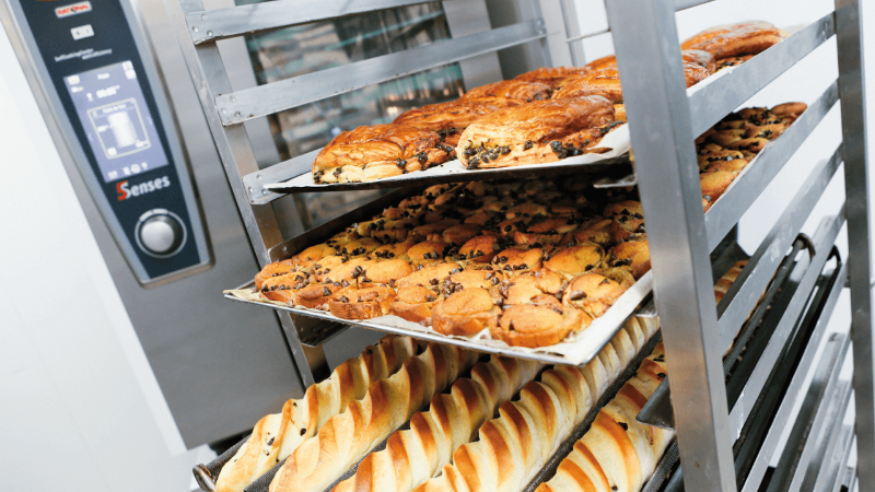 A display of freshly baked pastries and bread in a Rational oven, showcasing different baked goods on trays.