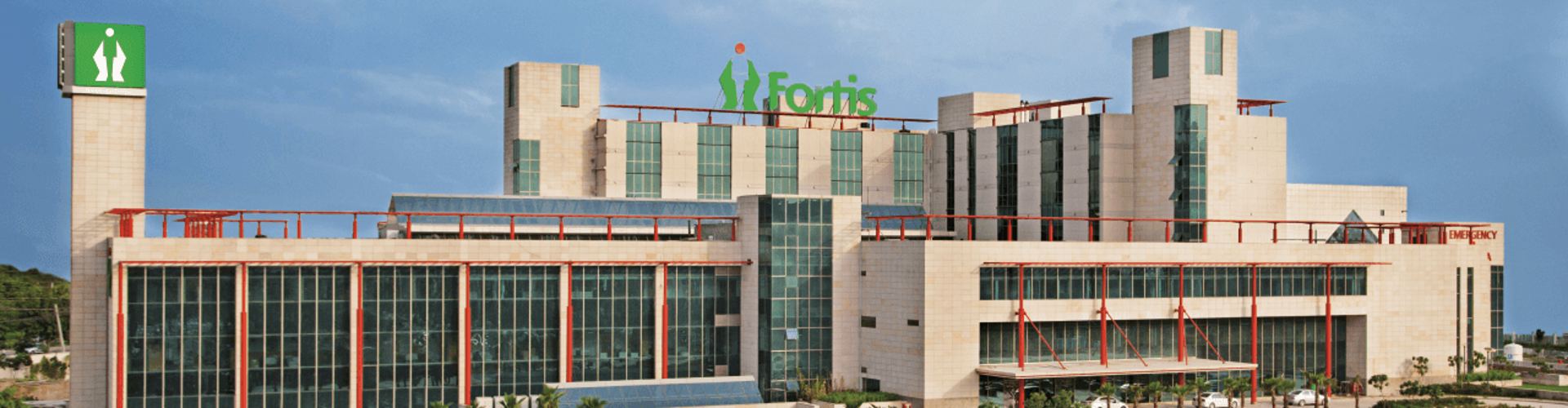 The exterior of Fortis Hospital with a large sign and the word ‘EMERGENCY‘ visible on the building.