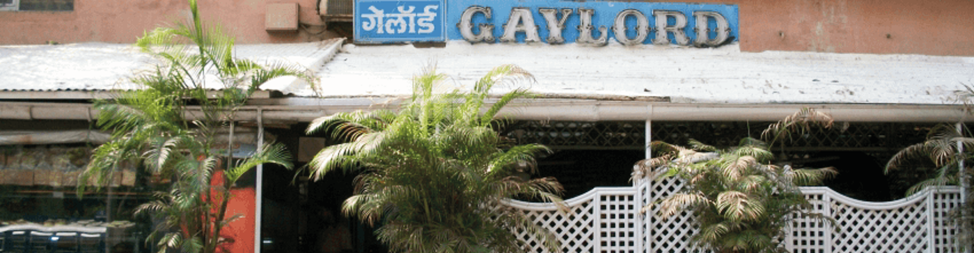 The exterior of a restaurant named Gaylord, with plants on either side of the entrance and a sign overhead.