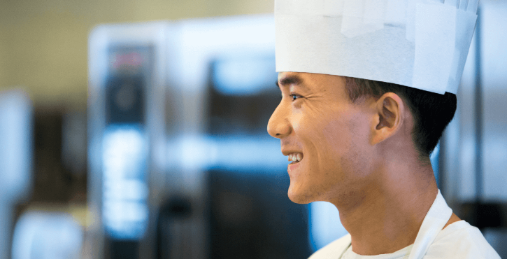 A happy chef working with a RATIONAL appliance.