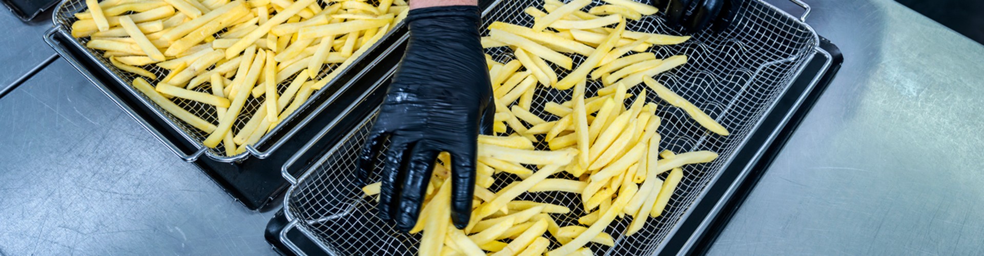 Chef con guanti sistema patatine su teglie per RATIONAL iCombi Pro forno professionale.
