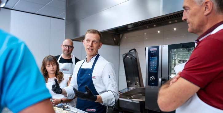 Chef explaining cooking with RATIONAL iCombi Pro combi oven and iVario Pro in a training session.