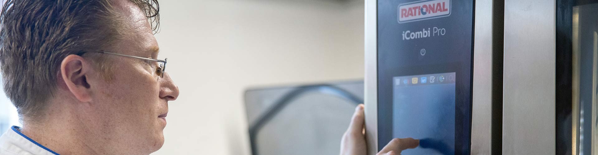 Chef operating the touchscreen of an iCombi Pro combi-steamer.
