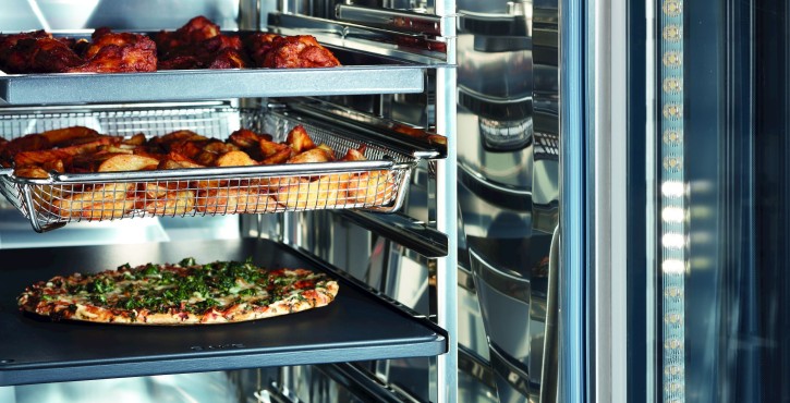 iCombi Pro oven with a pizza, roasted potatoes, and chicken inside.