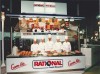A 1995 trade show photo featuring five chefs in white uniforms standing behind a display of food, with cooking equipment and the Rational logo in the background.