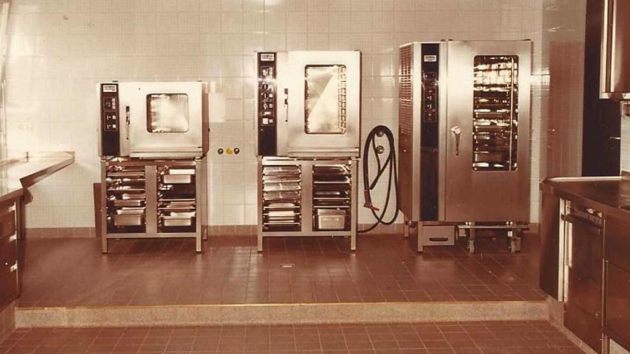 A vintage kitchen training center featuring three Rational ovens, with stainless steel surfaces and a tiled floor.