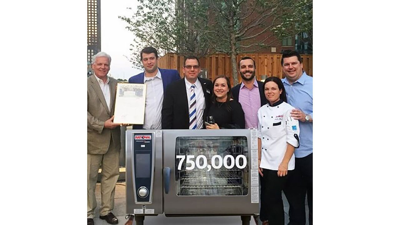 Group photo celebrating the sale of the 750,000th Rational unit, featuring the new owner and Rational representatives.