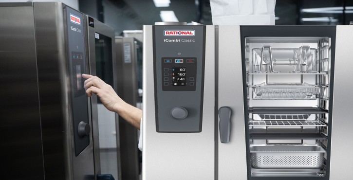 A person operates the iCombi Classic by RATIONAL via the touch display, with the interior of the unit visible.
