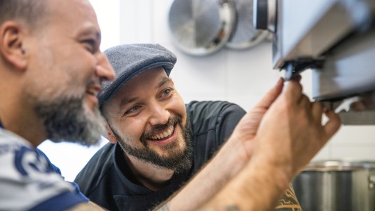 Two men inspect a RATIONAL iCombi Pro together.
