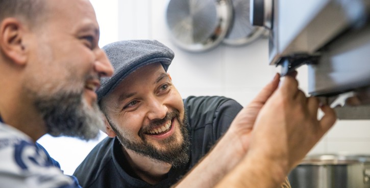 Two men inspect a RATIONAL iCombi Pro together.