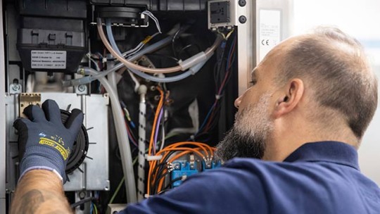 Technician works on the internal components of a Rational iCombi Pro.