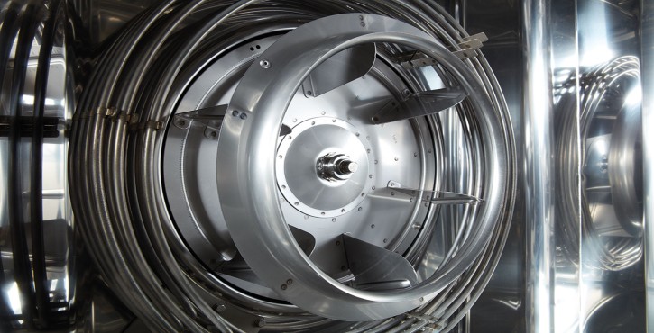 A close-up of a stainless steel centrifugal grease trap with visible rotating components and pipes.