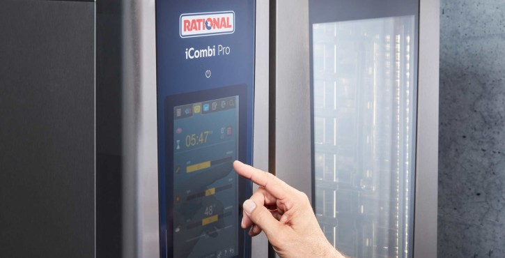 Main utilisant l’écran tactile du RATIONAL iCombi Pro four mixte avec affichage des paramètres de cuisson.