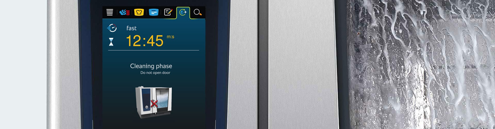 Close-up of the Rational iCombi Pro, displaying the cleaning phase on the screen with a message not to open the door.