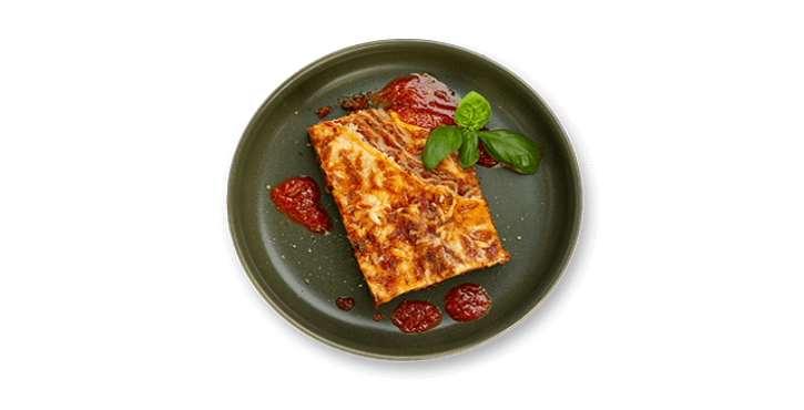 Slice of lasagna with tomato sauce and basil on a dark green plate.