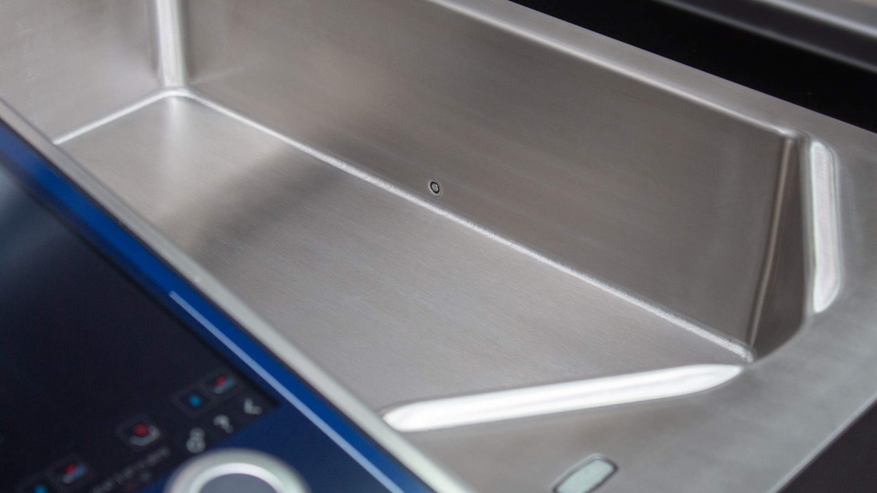 Close-up of a stainless steel pan with a temperature sensor in a cooking unit.