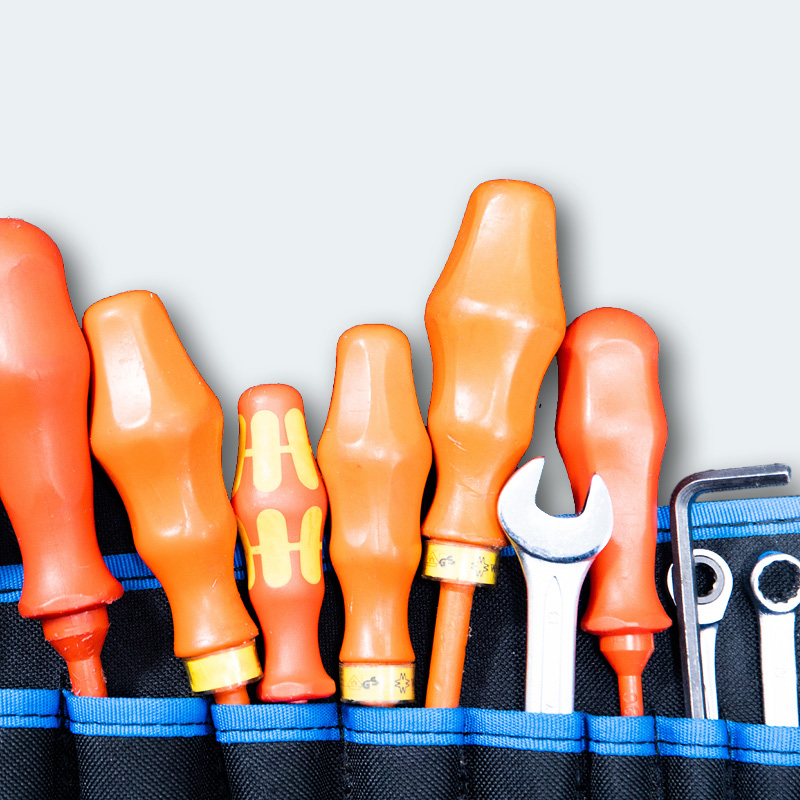 Insulated screwdrivers, spanner and hex keys in a tool pouch.