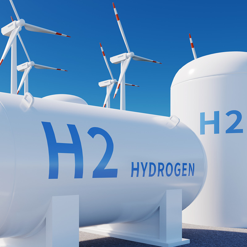 Hydrogen storage tanks with wind turbines symbolising renewable energy.