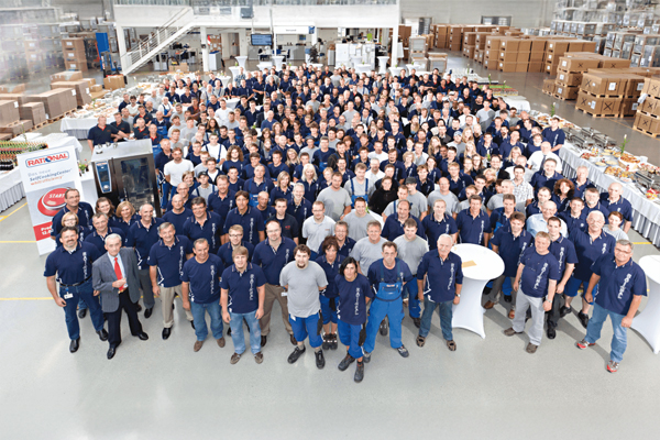 Historic photo of RATIONAL team celebrating the 100,000th combi-steamer unit produced.