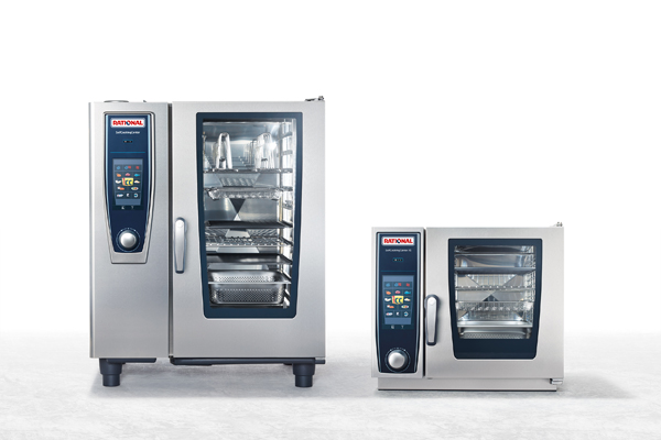 Historic photo of a RATIONAL trade fair booth with five chefs in white uniforms standing in front of a RATIONAL combi-steamer, showcasing various dishes and ingredients.